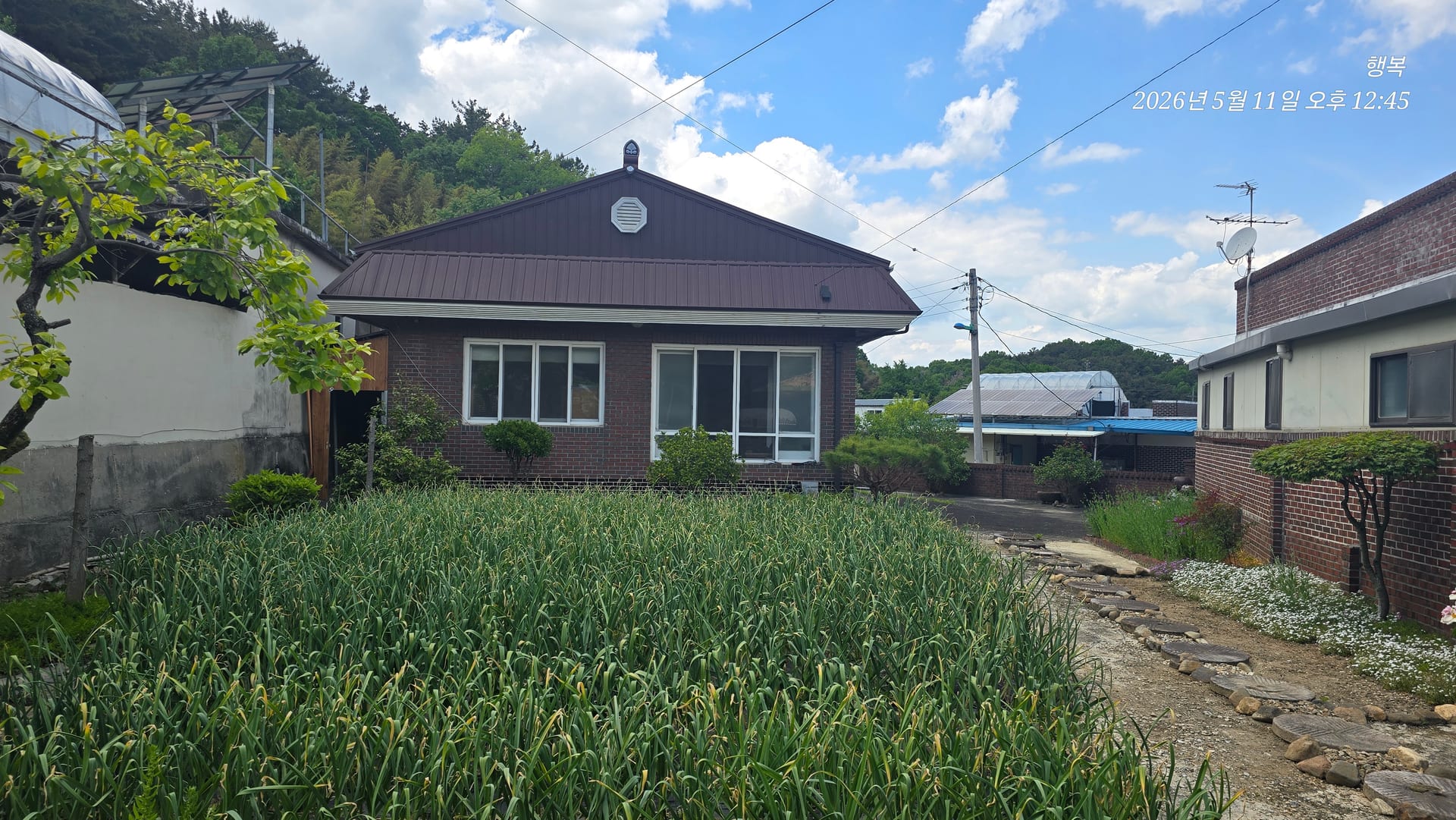 Red-brick house with a vegetable garden below Gwangju Lake